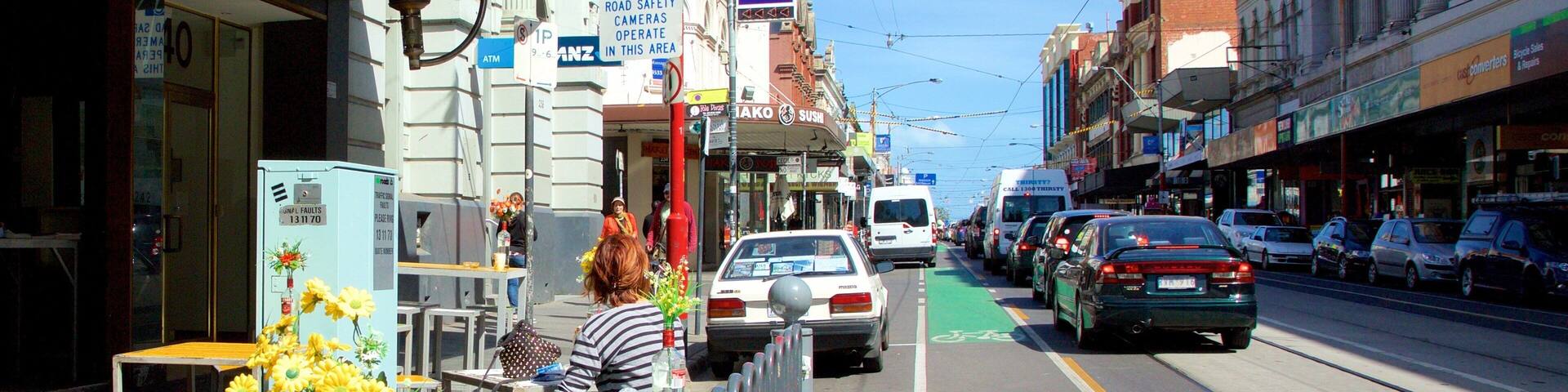 A street with shops, a bakery, and a sushi restaurant.