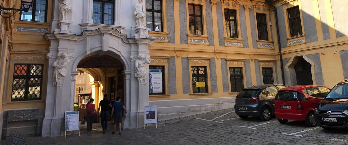 A historic building with ornate sculptures and a red-tiled roof.