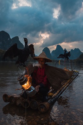 If you walk along the riverside in Xingping after sunset, you can see fishermen gather here to fish, on cormorant-perched, gas-lit bamboo rafts.