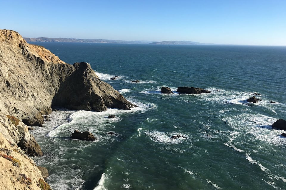 A rocky coastline with waves crashing against the shore.