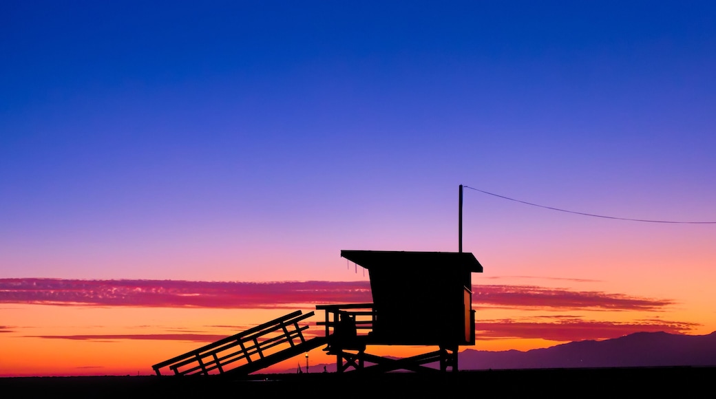 Sunset behind a lifeguard tower on the beach in Los Angeles, CA.