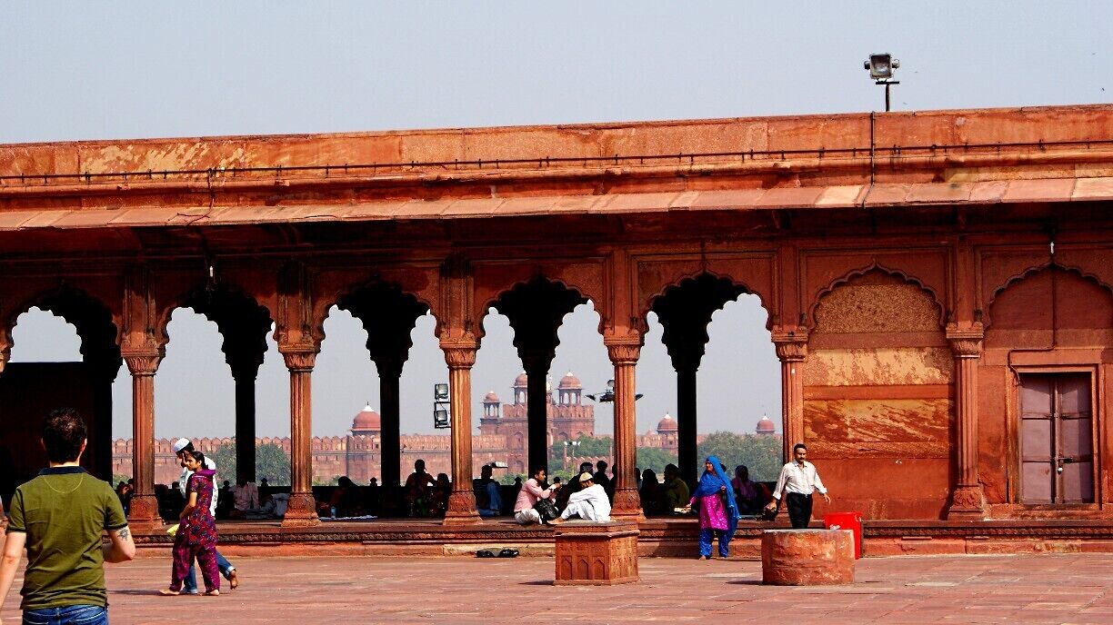 Exploring the grounds of Jama Masjid, the largest mosque in India. You can see the imposing Red Fort in the background.