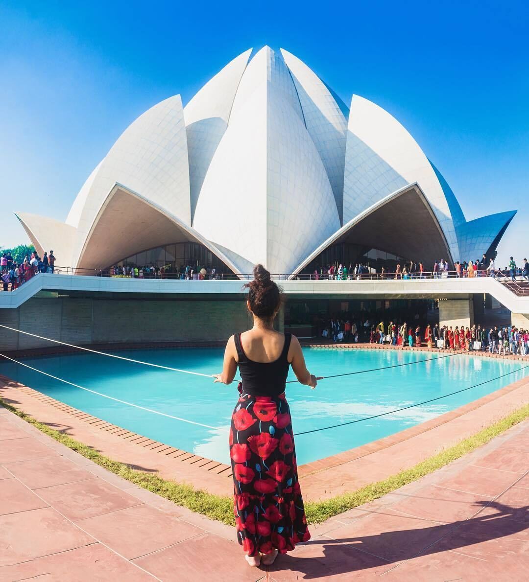 🌷"Like a lotus flower we too have the ability to rise from the mud, bloom out of the darkness and radiate into the world" 🌎 -------------------------------------------- The Lotus temple near Nehru place park in New Delhi is a house of worship for the Baha’i religion and had received 100 million visitors by 2014, making it one of the most, if not the most visited building in the world.

It is said to be the mother temple of the Indian subcontinent and has received numerous awards and features in newspapers and magazine articles.

It is the first temple in Delhi to utilize solar power, which fulfils about 25% of its energy needs and saves it 120,000 rupees a month in electricity bills.

The twenty-seven marble-clad “petals" of the temple symbolise comprehensiveness, oneness and unity, in keeping with all Baha’i Houses of worship the world over. Nine turquoise-hued pools also surround the structure, with overhead walkways passing between each gap between the pools (nine in total). Construction of the temple began on April 21, 1980 and the edifice was formally dedicated to the Unity of God, Unity of Religion and Unity of Mankind on December 24th, 1986. The total cost was $10 million.

The architect was an Iranian named Fariborz Sahba. The UK firm Flint and Neill undertook the structural design and the actual construction was done by ECC Construction Group of Larsen and Toubro Limited.

The temple is open to all people and all religions who wish to pray, reflect and worship. There are no idols inside the temple interior, which has nine entrances, holds 2,500 people and consists of an expansive hall with a 40 m high ceiling, furnished with arcing rows of wooden benches that are fitted with marble seat slabs. Photography is prohibited inside and several members of staff were present to hush people while they filed into the temple and to enforce the no photography rule, so we didn’t get a chance to capture the interior.

We visited the temple on a Sunday and the crowds were immense, excluding any possibility of taking immaculate images. Entry to the temple is free but the queue extended for hundreds of metres along the footpath from the main entrance, where security checks were causing a huge bottleneck. Here one has to relinquish one’s camera bag and daypack and place them on the conveyor belt that runs past the x-ray machine. Then one must pass through a door frame metal detector and if that beeps a security guard will manually grope your pockets and body to make sure you’re not carrying any weapons. From follow the avenue between the well-manicured gardens, which are cordoned off to make them inaccessible to the public, and kept verdant by myriad sprinklers spraying out thousands of litres of recycled water every day. You must then remove your shoes and carry them inside a recycling bag when you reach the checkpoint at one of the nine turquoise-hued pools.