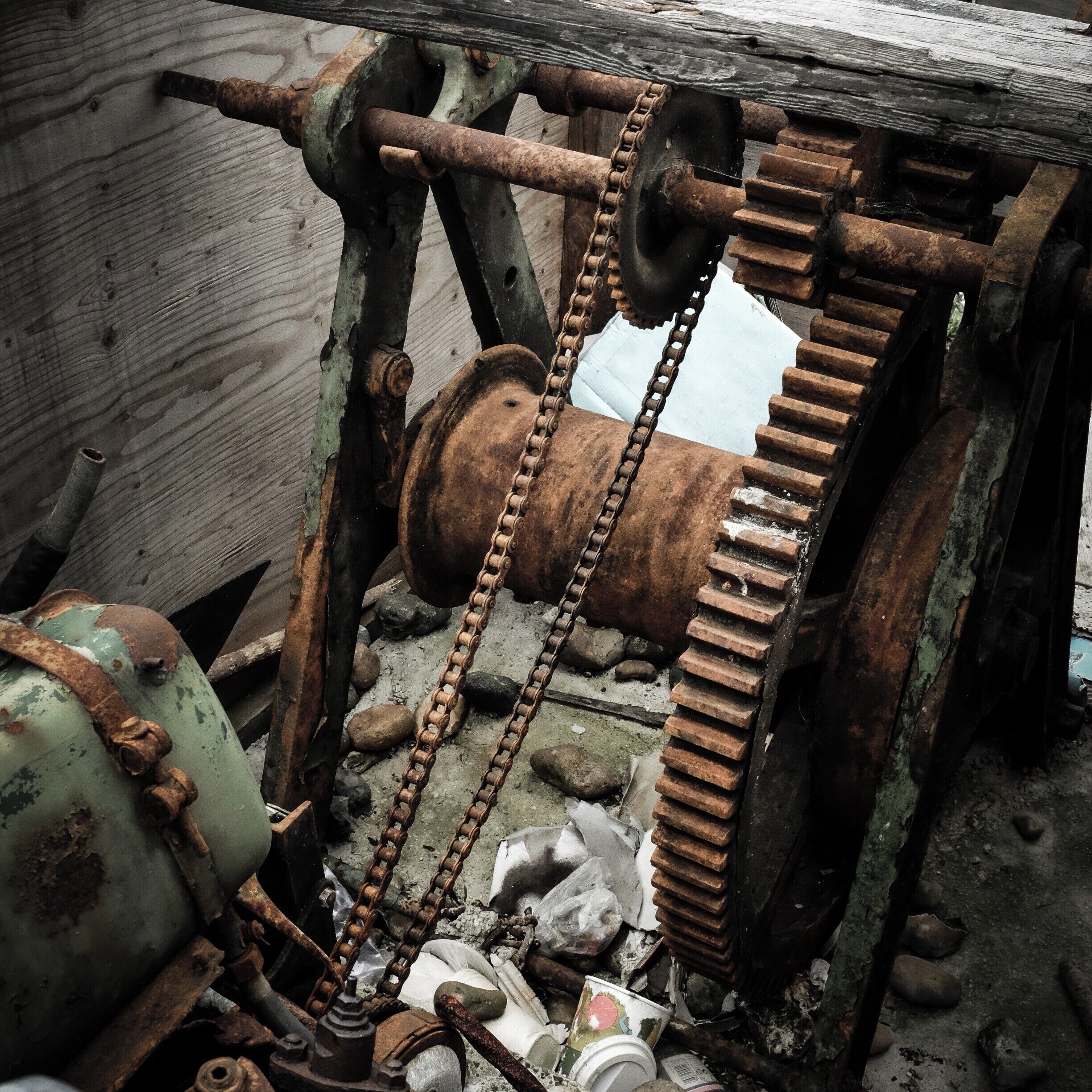Rusting boat winch on sea front.