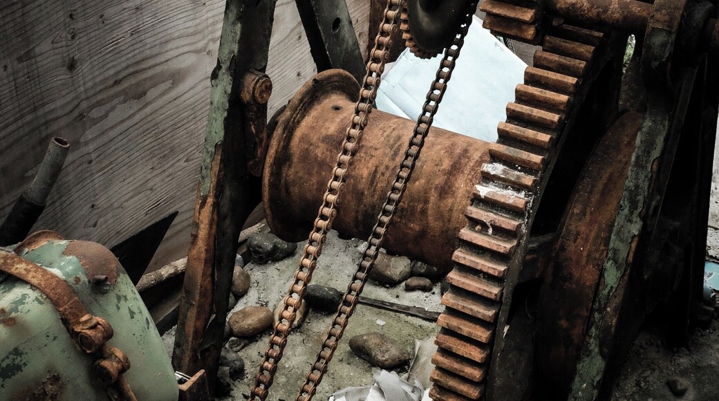Rusting boat winch on sea front.