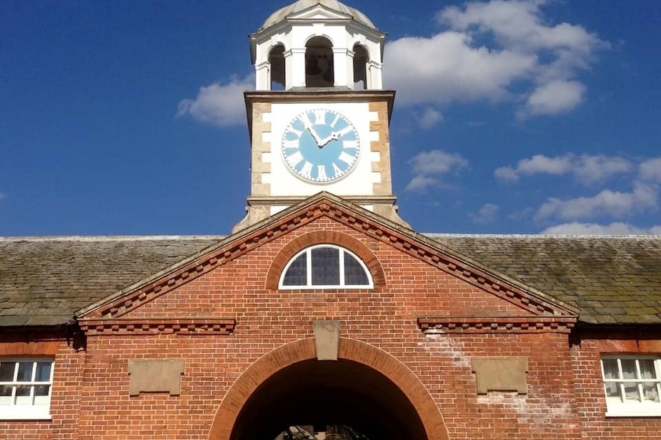 A brick building with a clock tower and arched windows.