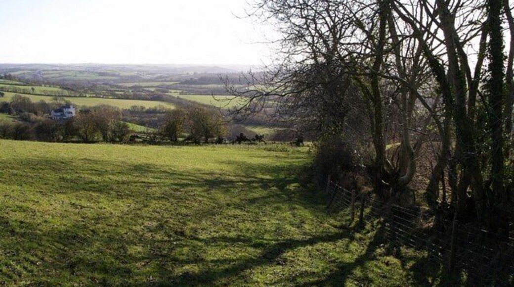 Field above Aller Cross Filleigh Footpath 15 drops down the side of this field, commanding views across the line of the A361 link road and the valley of the Nadrid Water. The shadows are cast by trees not just on the boundary of this field, but by those on a field boundary running off to the right. The building on the left, Snurridge, is in SS7028.