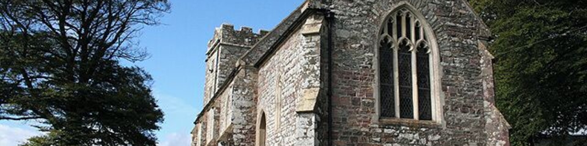 Twitchen: St Peters church. The structure, excepting the west tower which is slightly out of alignment with the nave and chancel was remodelled in the Victorian era. Many of the 19th century gravestones are of slate and their inscriptions are easily read. The church stands perched above the hamlet of cottages and farms