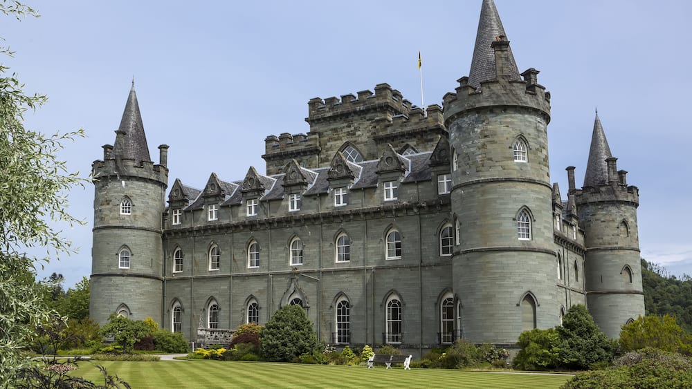 Un grand château doté de nombreuses tours et de fenêtres en arc.