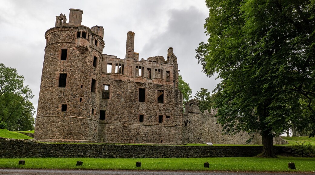 Huntly Castle in Scotland, UK in early evening with a stone wall and tree
