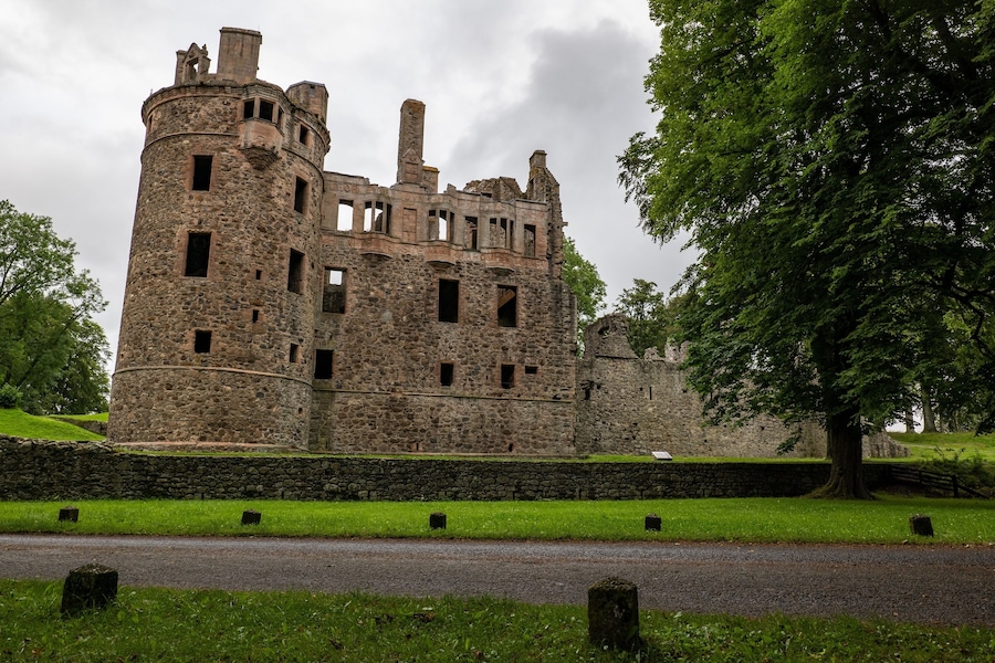 Huntly Castle in Scotland, UK in early evening with a stone wall and tree