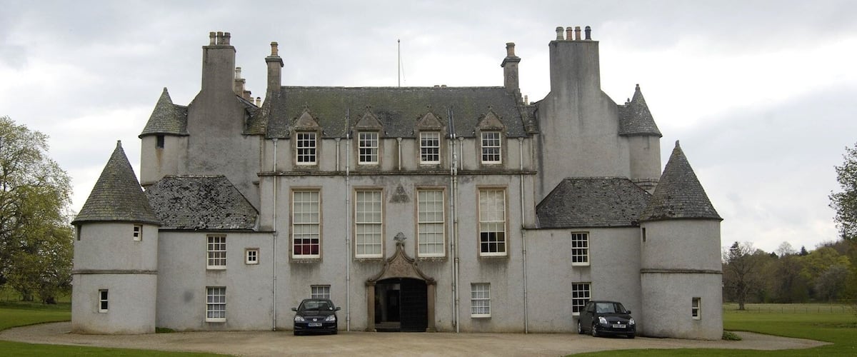 A large, historic building with multiple towers and a central entrance.
