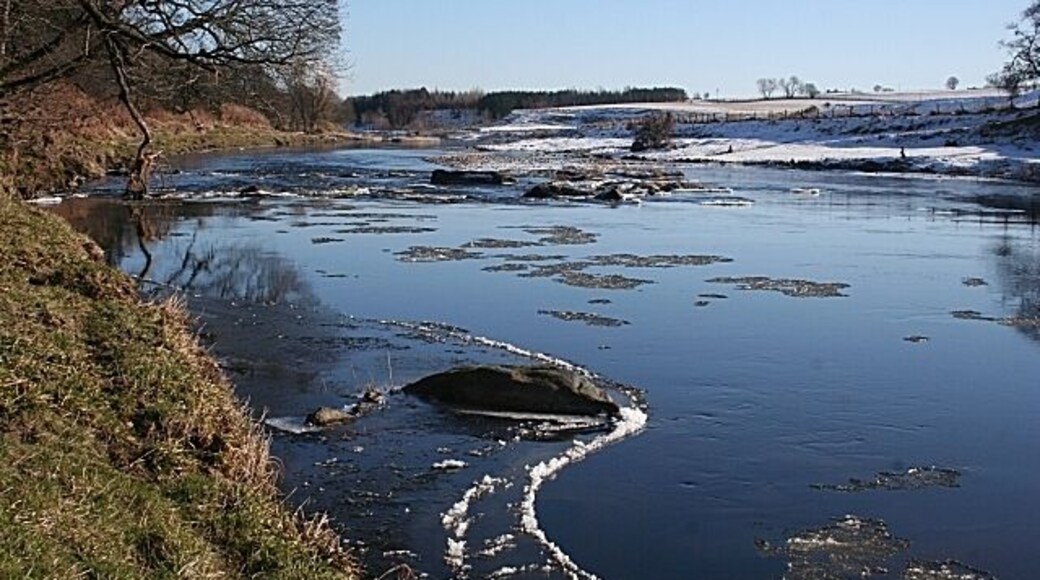 River Deveron This smooth reach of the river ends at the slight rapids just downstream. The shingle bank below the rapids is exposed, suggesting that the river level is not especially high.