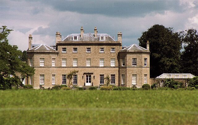 A large, historic building with multiple chimneys and a prominent entrance.