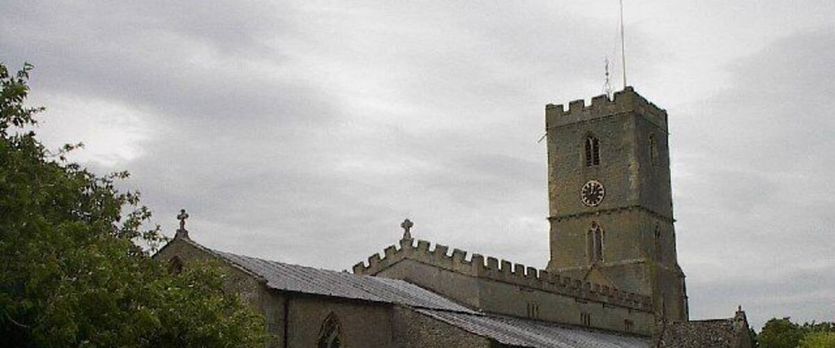 An old church with a clock tower and a graveyard.