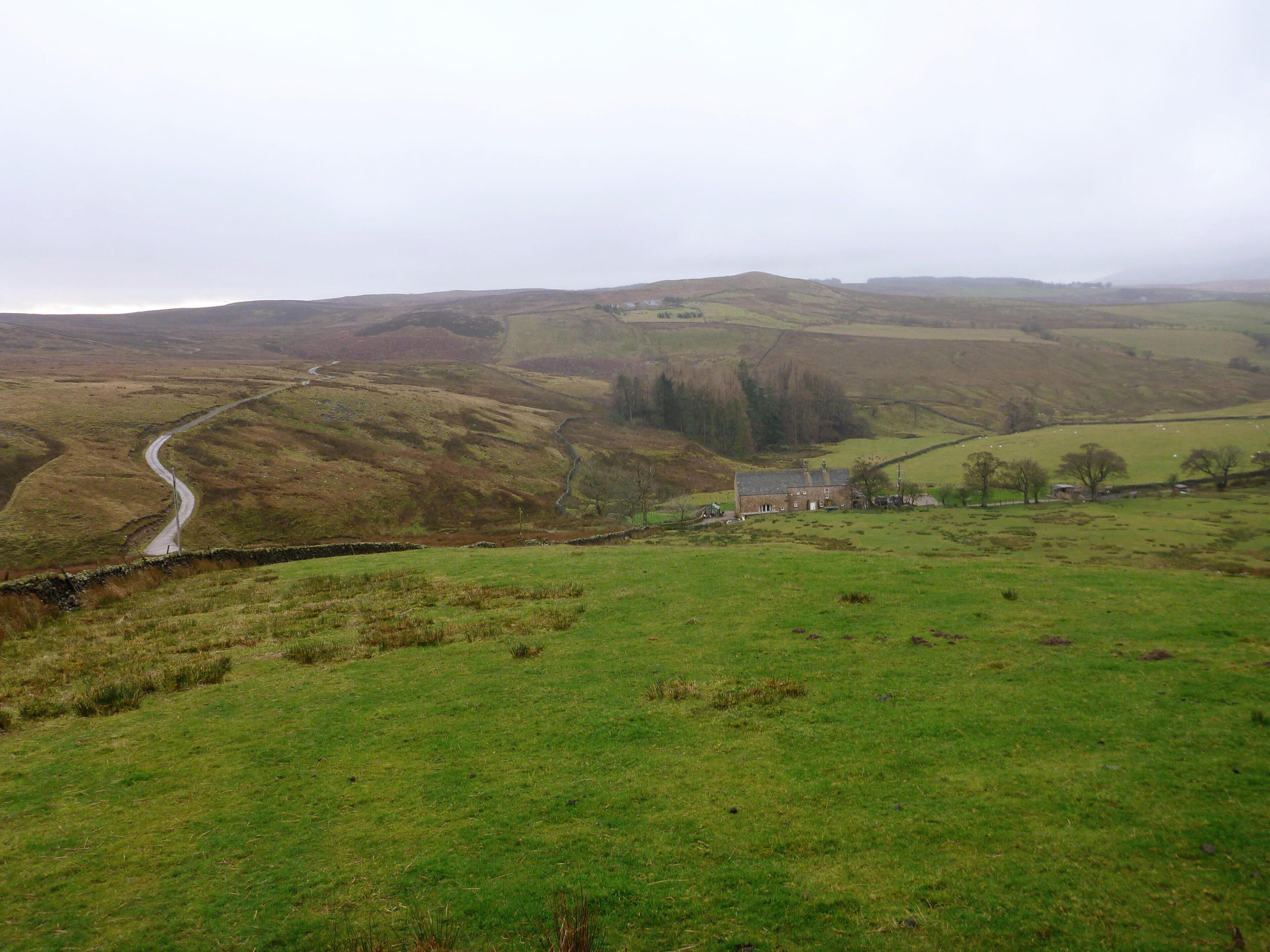 Lower Underhand and the track to Stone Fold. Seen just at the start of a period of heavy and persistent rain, the track to Stone Fold is wet and reflecting the leaden sky from its recently sealed surface.