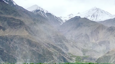 Un río con agua turquesa cristalina que atraviesa un paisaje nevado con montañas al fondo.