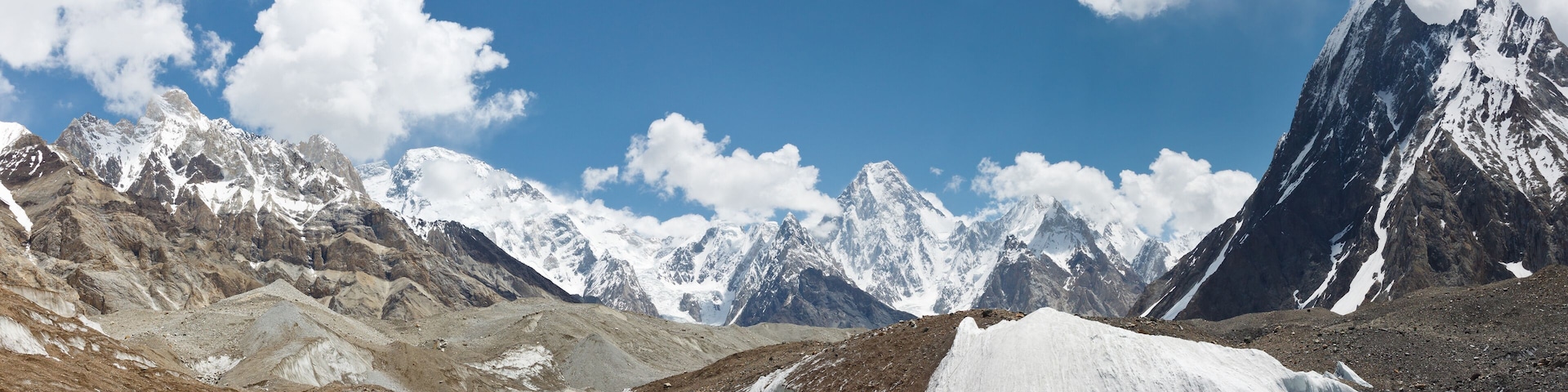 A mountainous landscape with snow-covered peaks and a clear blue sky.