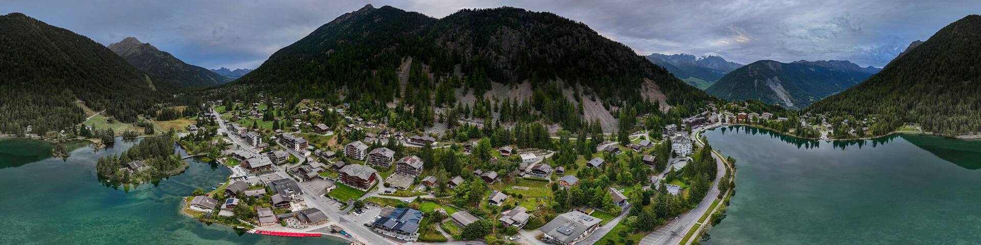 High resolution extreme color aerial panorama take with drone of the famous Swiss town of Champex Lac with its peaceful lake and alp mountains surrounding it part of the famous TMB- Tour du Mont Blan