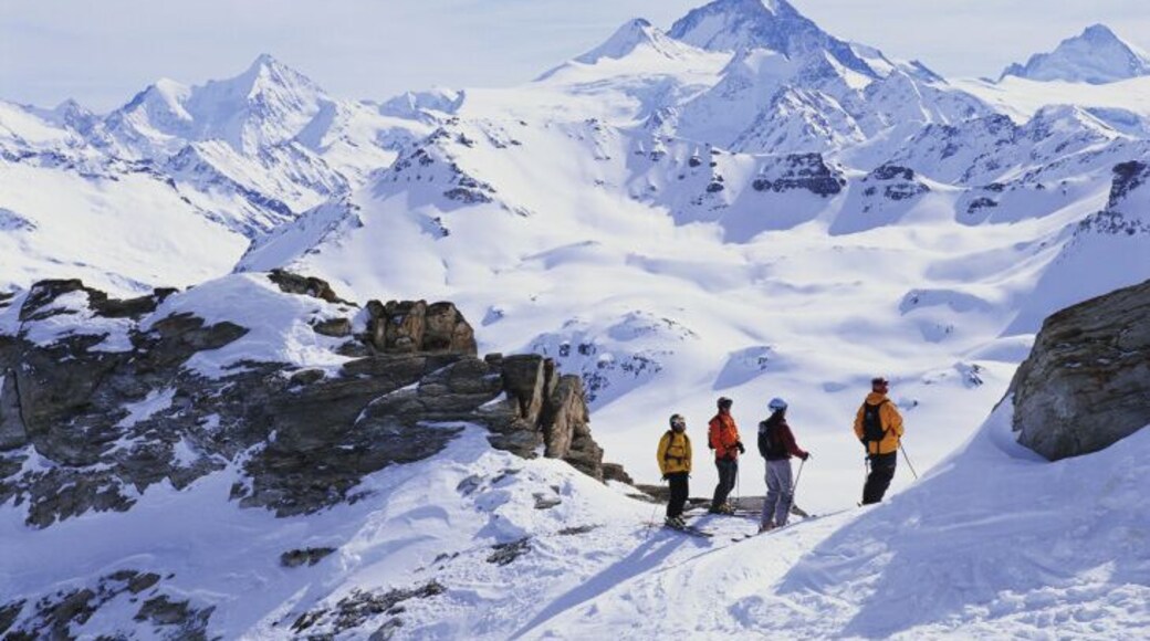 Switzerland, Valais, Grimentz, skiers pausing, looking at scenic vista