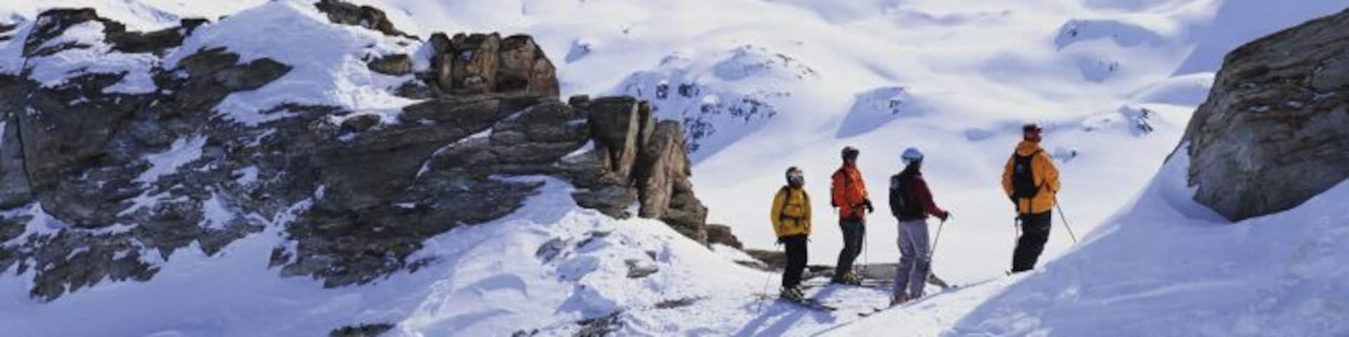 Switzerland, Valais, Grimentz, skiers pausing, looking at scenic vista