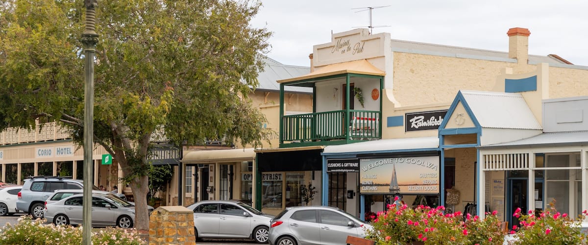 A street with cars, a hotel, and a shop named 'Rainsford'.