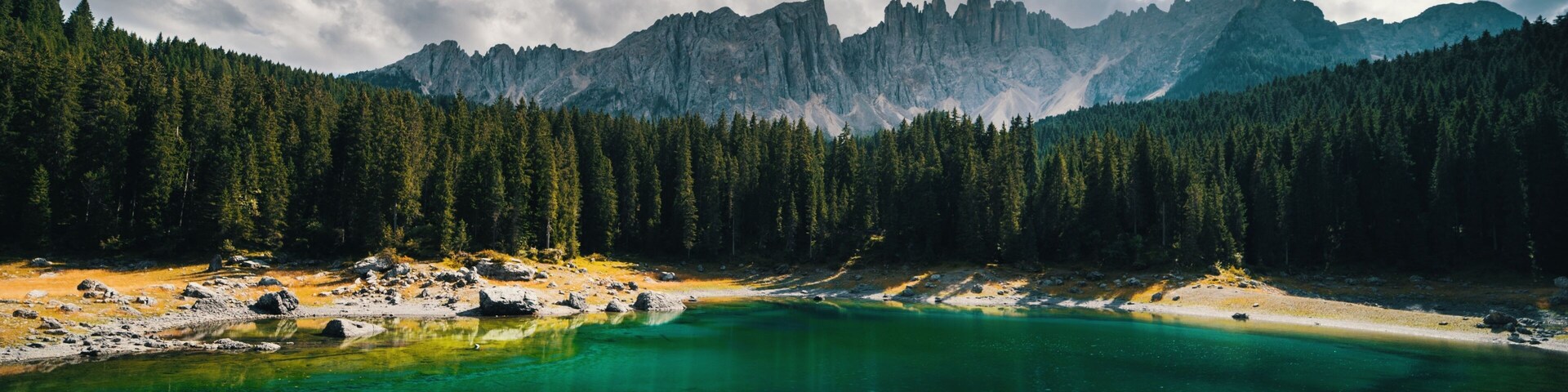 Un lago de montaña rodeado de un bosque denso y montañas escarpadas.