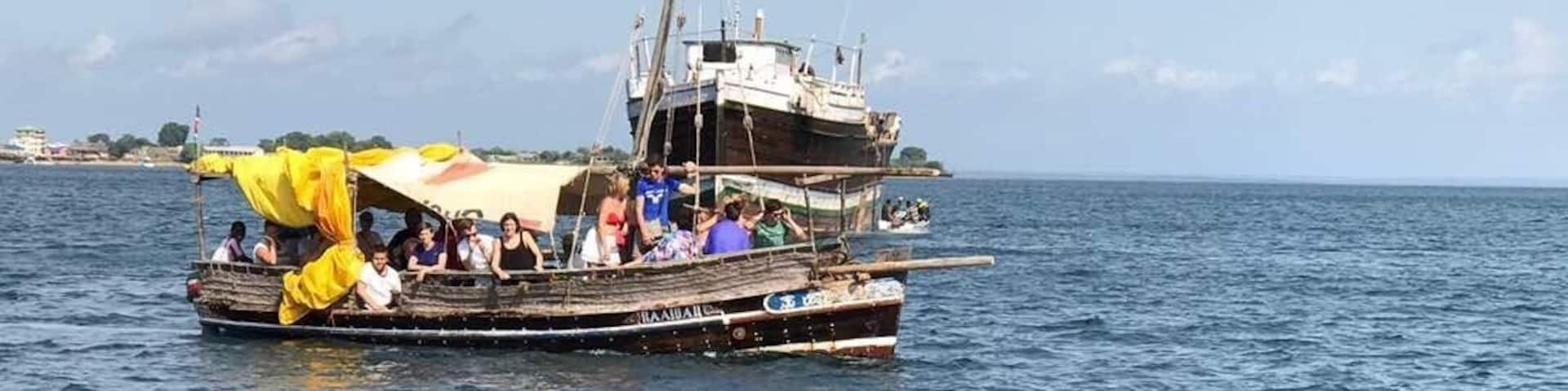A boat with passengers and dolphins in the water.