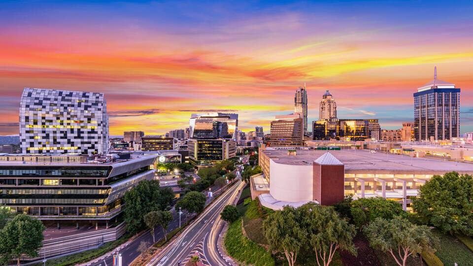 Sandton city skyline in the evening with beautiful twilight sky and illuminated buildings