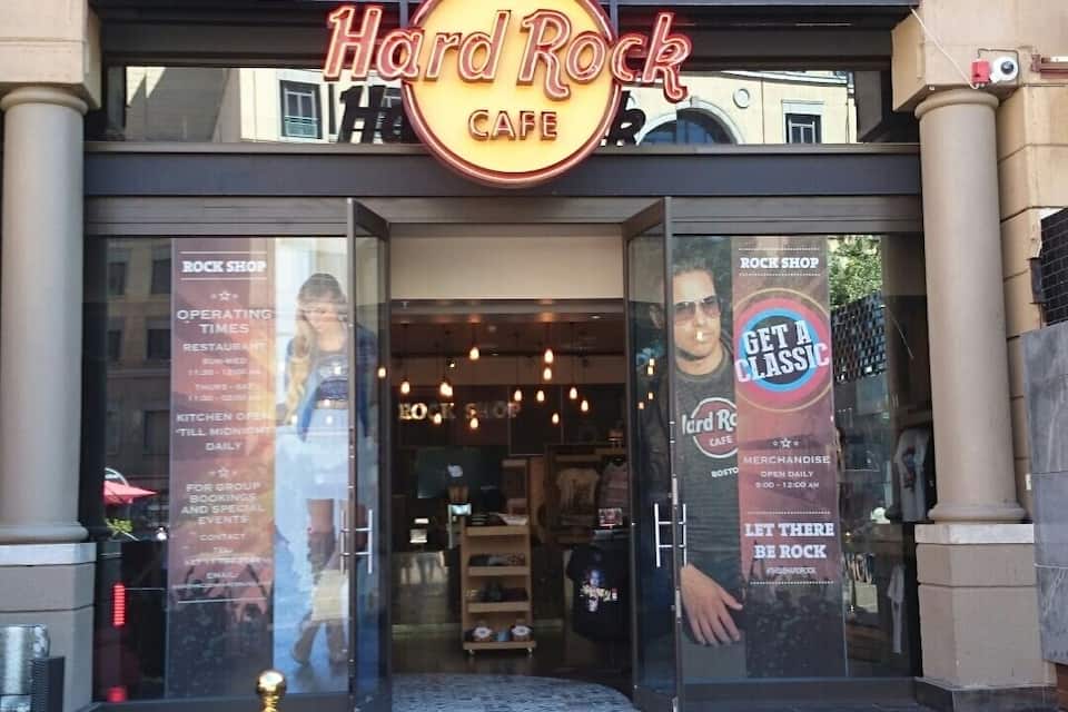 The Hard Rock Cafe entrance with a large arched window and a neon sign.
