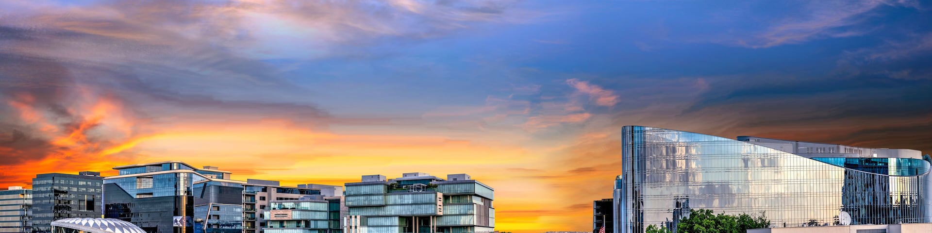 Un paisaje urbano con arquitectura moderna y un cielo al atardecer.