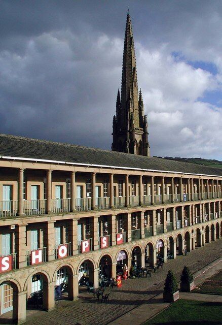 A historic building with a large arched entrance and the word "SHOP" visible on the facade.