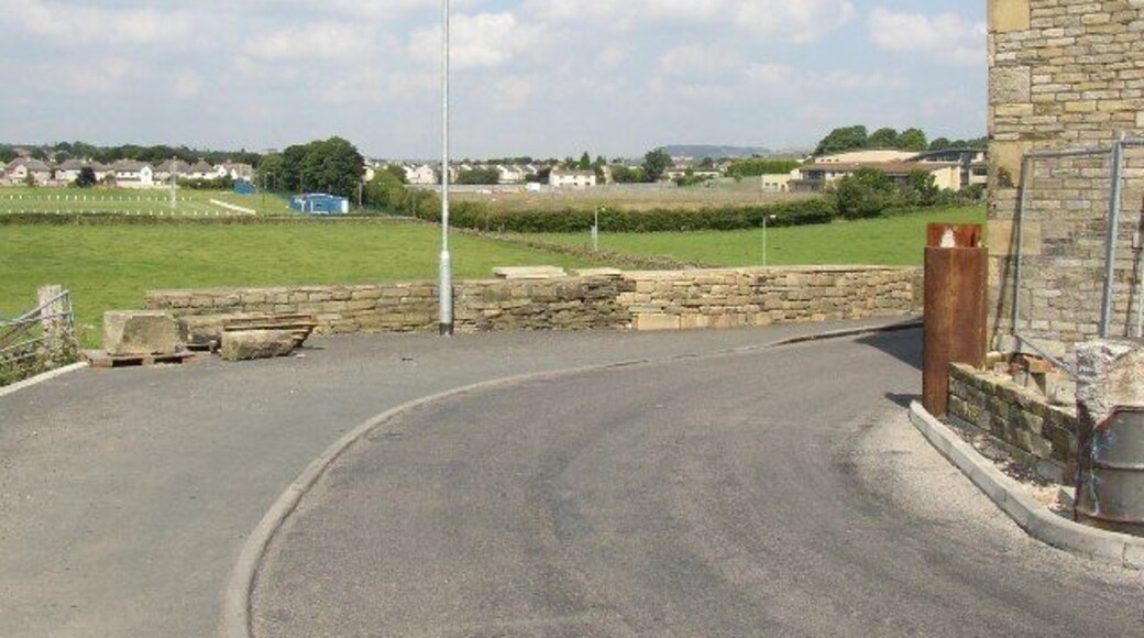 Exley Lane, Halifax. This is taken looking N from the sharp bend at SE101221. This is the medieval main road from Elland to Halifax. Round the corner the road bends bends left and slants up to the houses. There is a big new building on the hillside.
