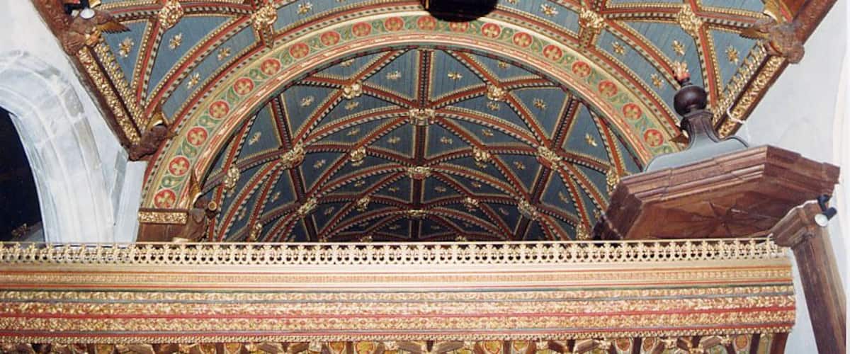 A detailed ceiling with geometric patterns and a hanging light fixture.