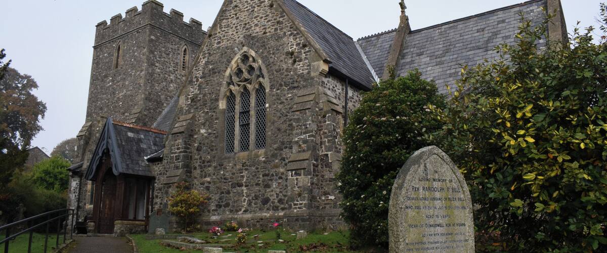A historic stone church with a pointed arch window and a bell tower.