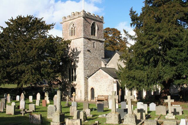 A church with a tower and a cemetery in the foreground.