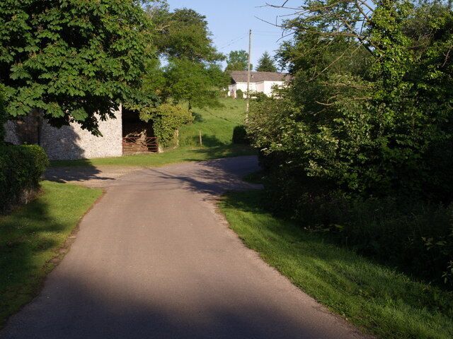 Lane at Widworthy. The lane past 443571 drops down to a bend past Widworthy Barton. In the background is Orchardleigh.