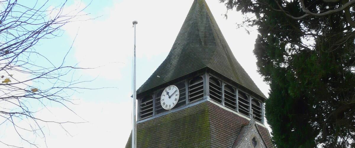 A church with a clock tower and a flagpole.