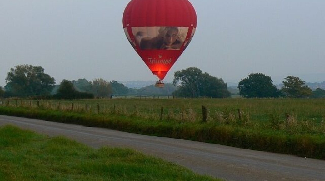 Hot air balloon, Hook, Wiltshire (1). A hot air balloon is about to land on a farm west of Swindon. The gas is being flared to maintain enough buoyancy to permit a soft landing. Time now 17.19 hours. Next image: 579465. Balloon registration G-KNIX.