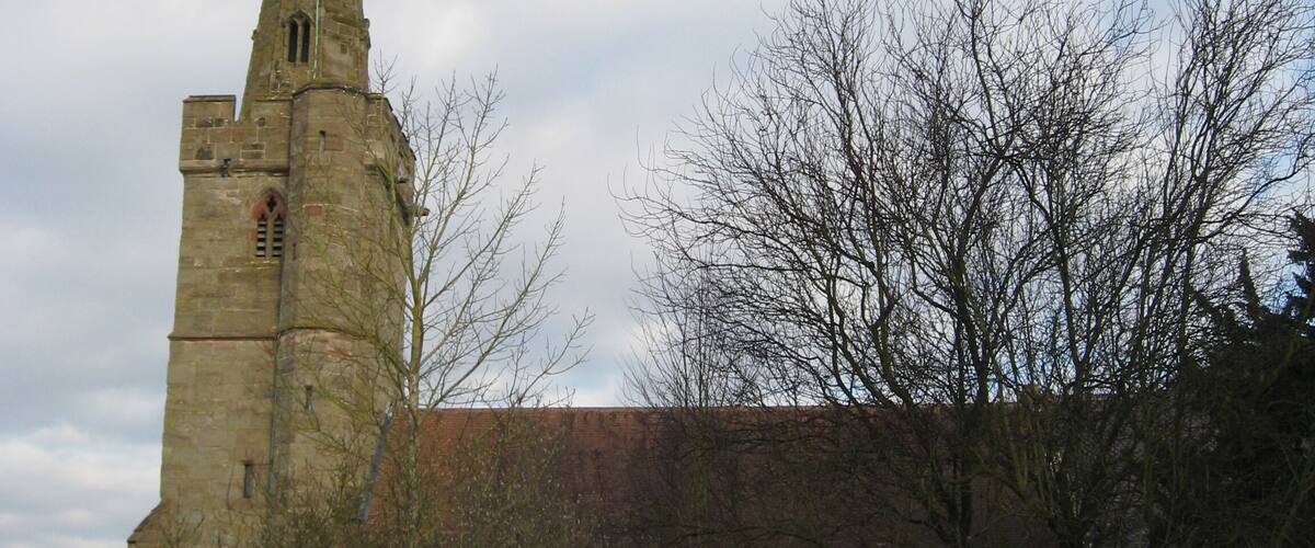 A church with a tall spire and a large arched doorway.
