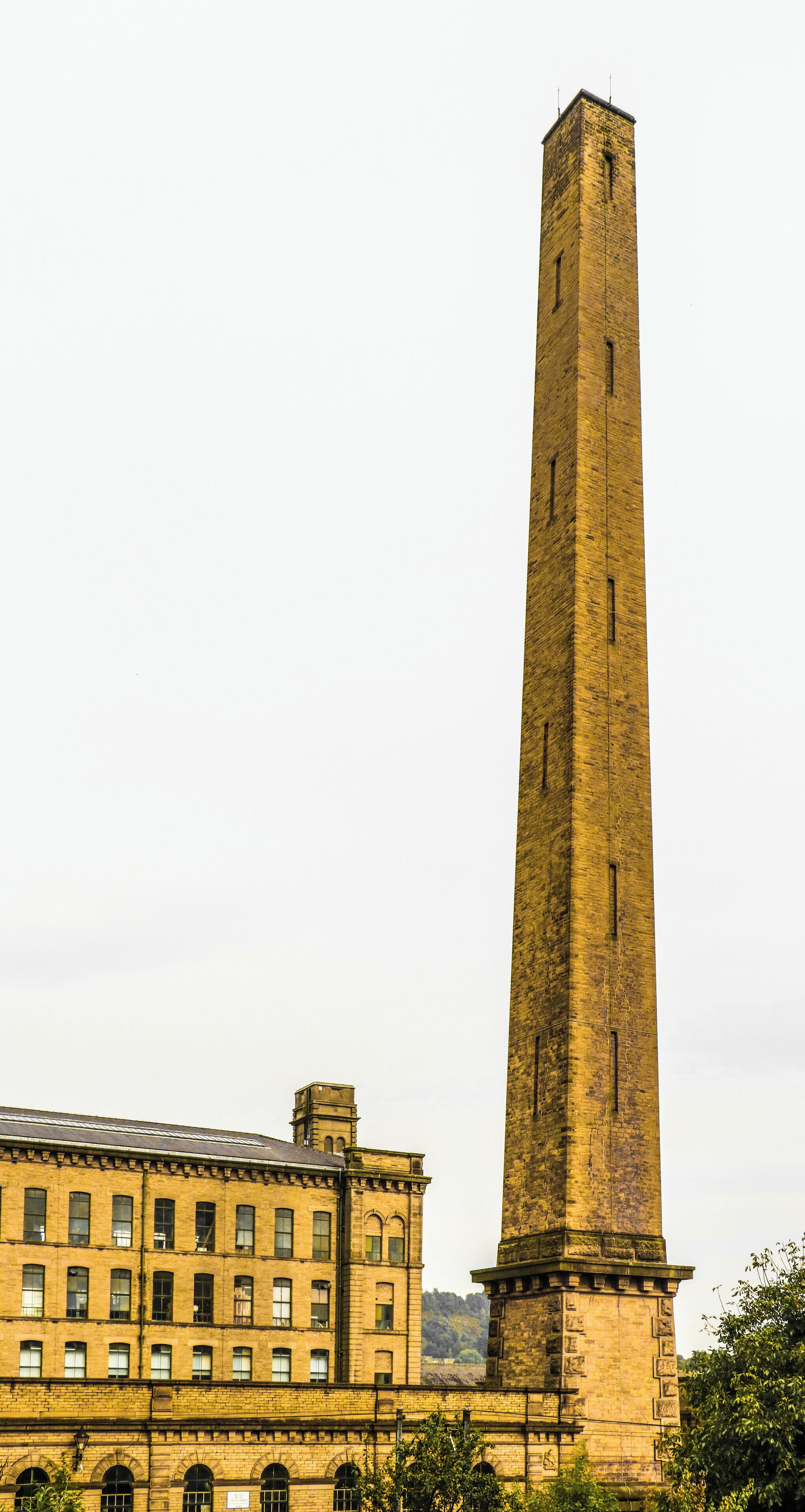 A tall brick tower with a smaller building in the foreground.