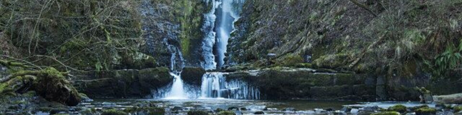 Scwd Einion Gam The waterfall Scwd Einion Gam translated means Waterfall of the crooked anvil. This photo was taken after a long spell of very cold weather