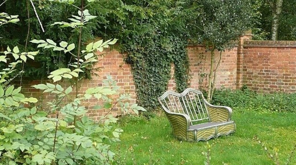 Time for a rest Wicker chair for two in a domestic garden in Yattendon.