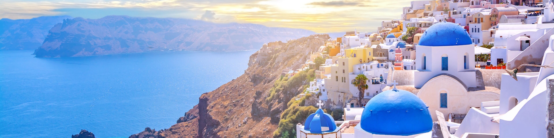 Beautiful Oia town on Santorini island, Greece. Traditional white architecture and greek orthodox churches with blue domes over the Caldera, Aegean sea. Scenic travel background.