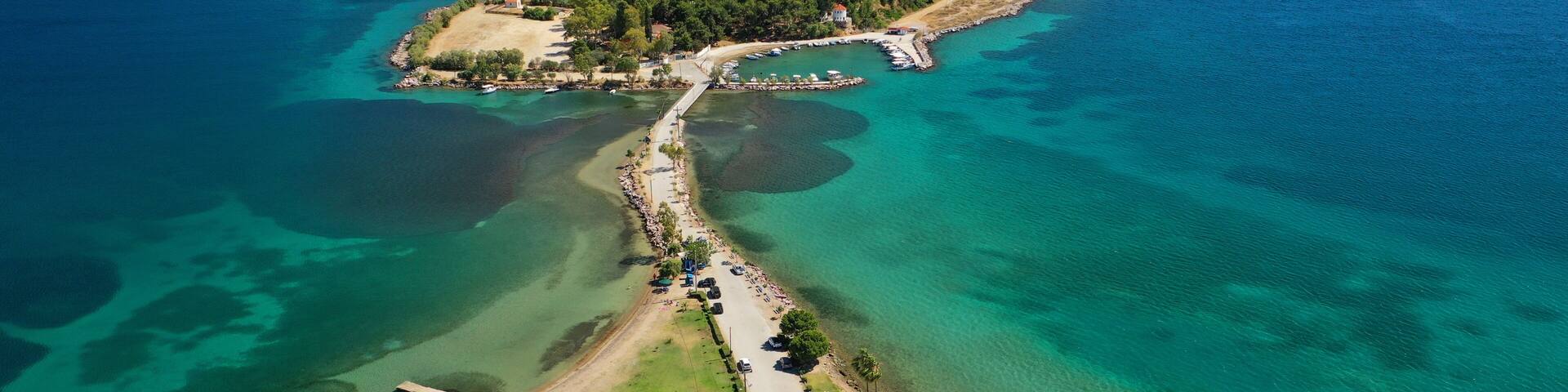 Aerial drone photo of famous island of dreams or Pesonisi connecting with small road with seaside fishing village of Eretria, Central Evia island, Greece