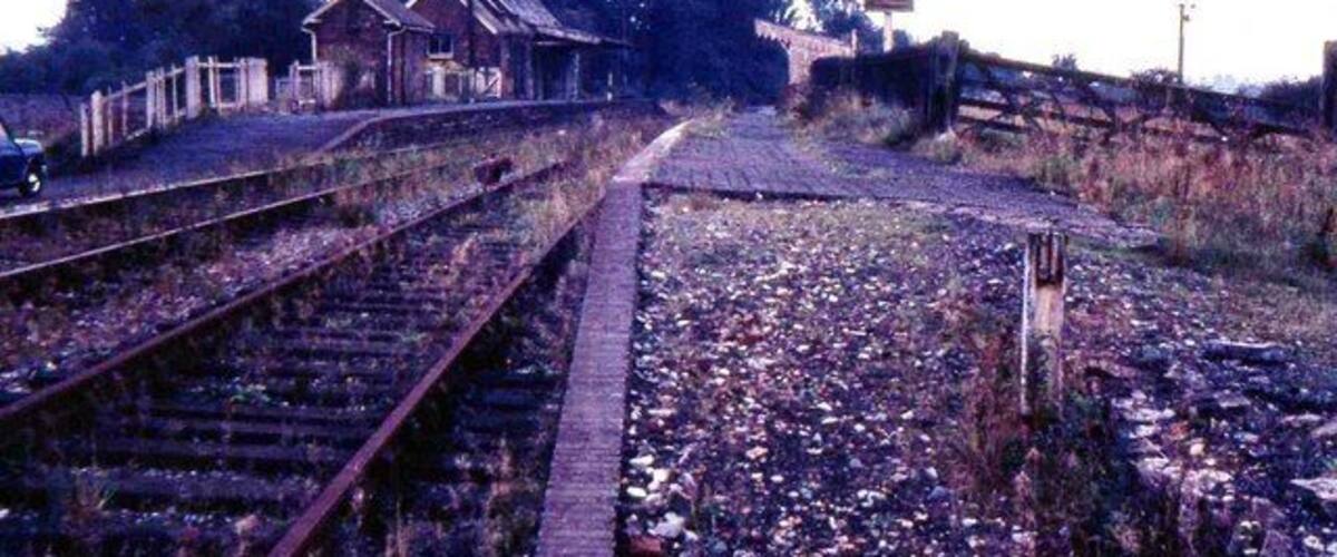 Railway tracks, a small building, and a fence.