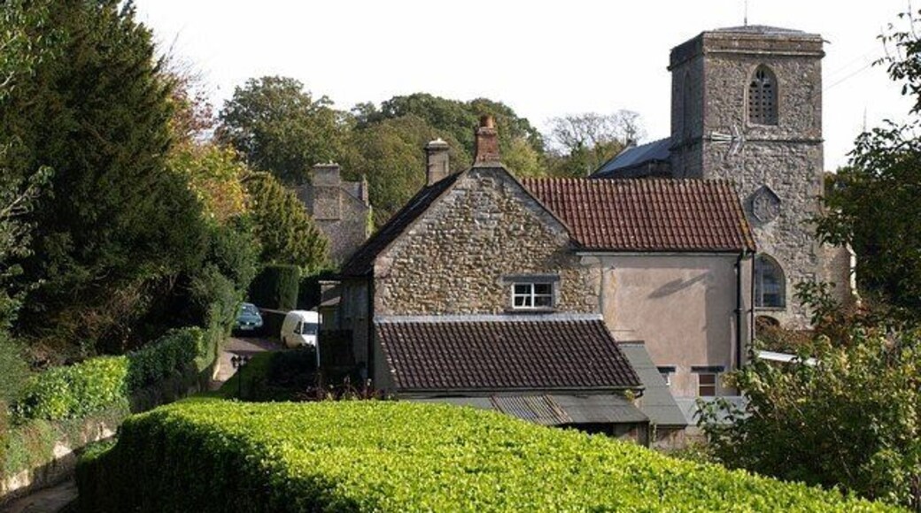 Approaching East Pennard church. The footpath from Home Farm approaches a cottage and the west end of the churchyard of 65801.