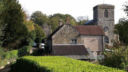 Approaching East Pennard church. The footpath from Home Farm approaches a cottage and the west end of the churchyard of 65801.
