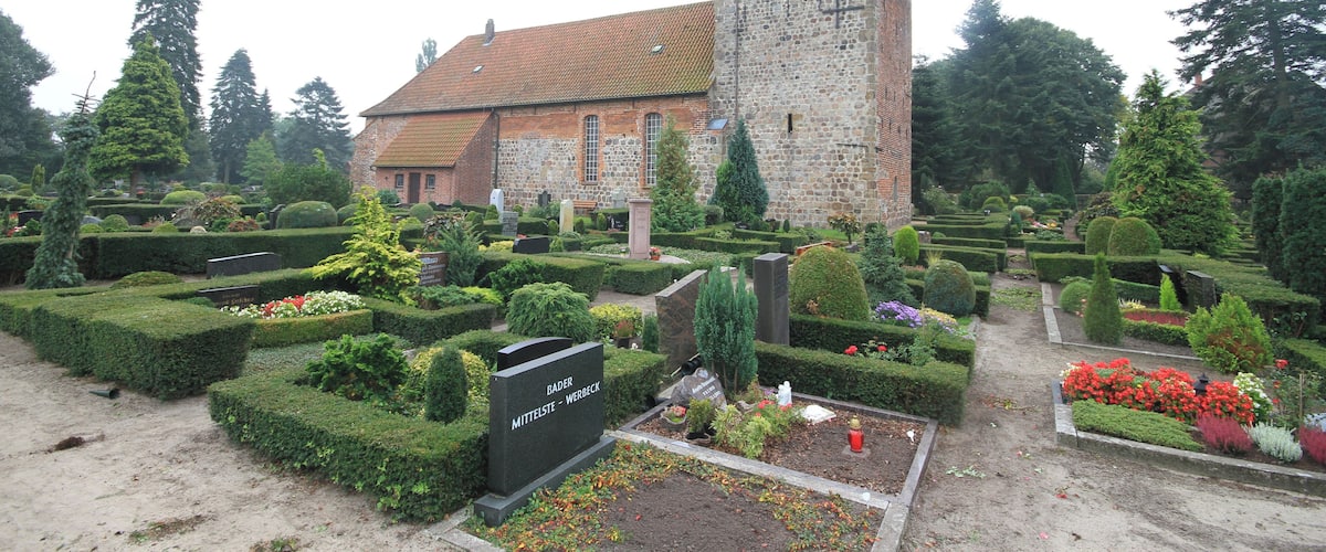 A cemetery with a church and a tall tower.