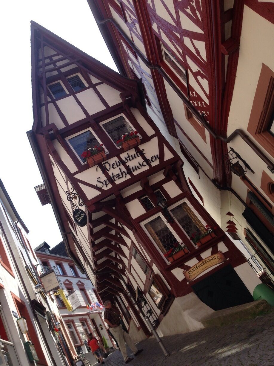 A traditional half-timbered building with signs for 'Dein Stuhle Spitztuschen' and 'Gasthof'.